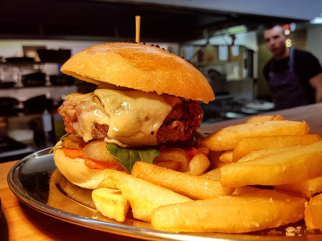 A highlight from todays specials: Lamb burger with red pepper hot sauce, pickled cucumber, provelone cheese, charred onion served with chips. Delicious. ?:@sandy_mckay92 #burger #lamb #goodfood #peppermintbay #specials #foodporn #cheesy #tasmanianfood