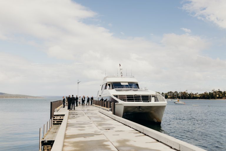 Guests disembarking a catamaran docked at a jetty